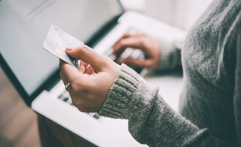 Frau bezahlt im Internet per Kreditkarte