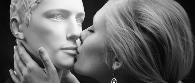 Frau küsst einen imaginären Mann alias Puppe