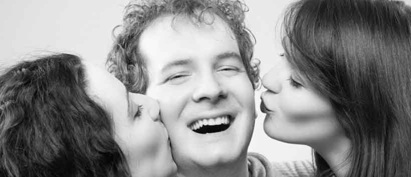 Junger Mann lächelt, weil sich zwei Frauen mit ihm Spontansex  wünschen