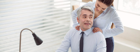 Erfolgreicher Manager wird von einer Mitarbeiterin im Büro angeflirtet